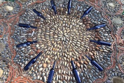 Mosaic of rocks, bottles and roofing tiles (c) Debra Lee Baldwin